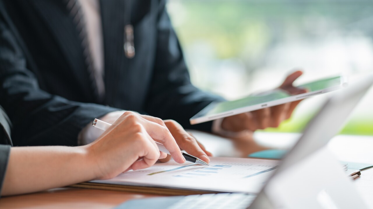 People looking at papers on a desk together.