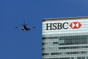 An airplane passing the offices of HSBC in the Canary Wharf district in London.