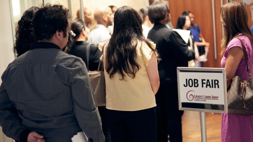 A picture of people standing in line at a jobs fair.