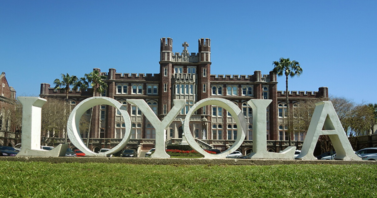 Loyola's campus quad bustling with activity, students playing frisbee, reading, and relaxing on green grass.