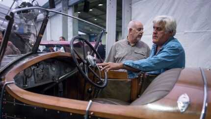 Jay Leno, right, views a 1925 Renault SA 40 CV Torpedo Skiff vehicle at the 2019 Pebble Beach Concours d'Elegance in California.
