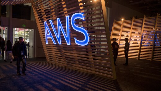 Attendees walk past a signage for Amazon Web Services (AWS) Summit in San Francisco, California, U.S., on Wednesday, April 19, 2017. Amazon.com Inc. Web Services chief executive officer Andy Jassy is leading a push into artificial intelligence to boost Amazon's cloud computing, which commands about 45 percent of the market for infrastructure as a service, where companies buy basic computing and storage power from the cloud. Photographer: David Paul Morris/Bloomberg