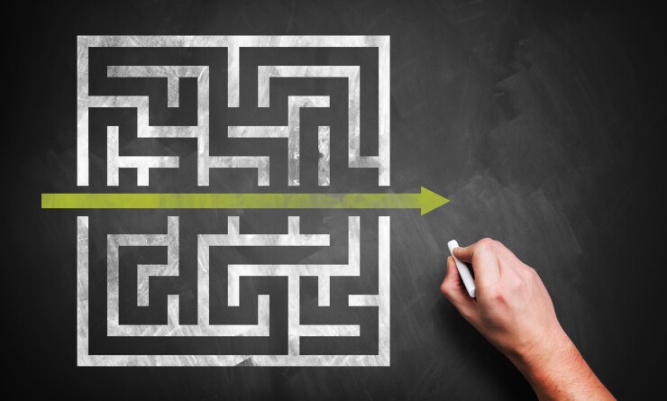 Rendering of a hand drawing a shortcut through a maze on a chalkboard.