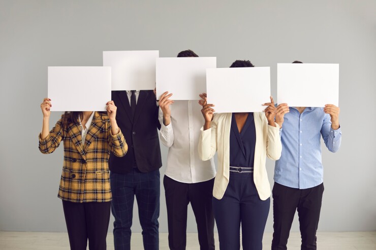 A group of people holding up individual pieces of paper that covers their face