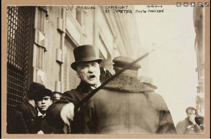 A picture of J.P. Morgan in 1910 angrily waving a cane as he walks down the street.