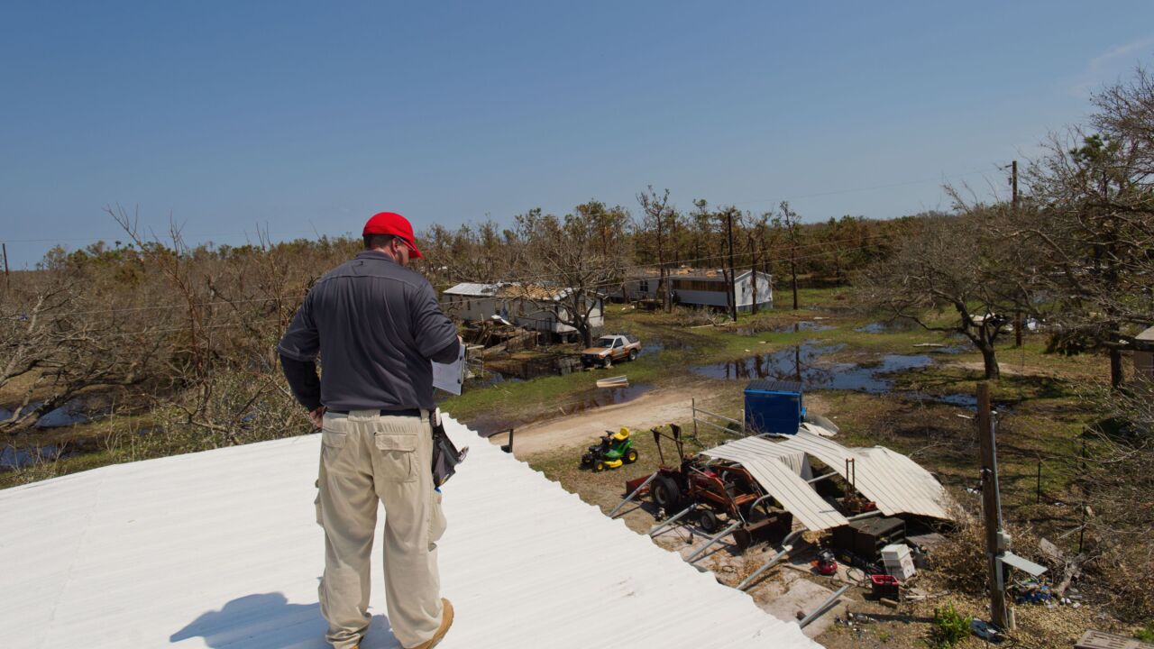 A State Farm catastrophe claims adjuster inspects a roof as debris sits near a home affected by Hurricane Harvey in Rockport, Texas, U.S., on Saturday, Sept. 2, 2017. Hurricane Harvey inflicted damage on 1.7 million homes that could top $11.5 billion in insured losses, according to CoreLogic Inc.