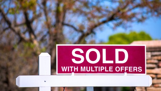 SOLD With Multiple Offers real estate sign near purchased house indicates hot seller's market in the desired neighborhood. Blurred outdoor background