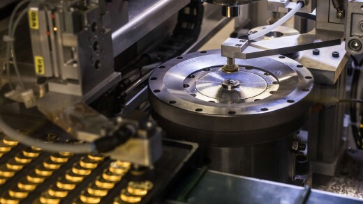 A coin press stamps gold bullion coins during their production at Britain's Royal Mint.