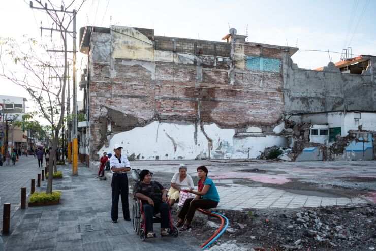 Residents sit at the site of a former bus terminal, destroyed during the 2017 earthquake, in Jojutla, Morelos state, Mexico, on Saturday, Sept. 15, 2018. A powerful earthquake jolted Mexico City on September 19, 2017, killing 370 people and injuring more than 6,000. The quake struck 32 years to the day after a temblor with an 8.0 magnitude killed 5,000 people.