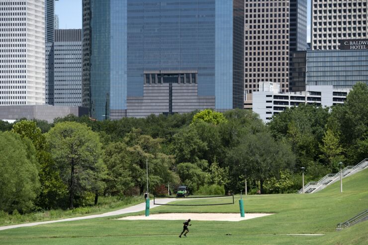 A runner jogs in Buffalo Bayou Park during a heatwave in Houston, Texas, US, on Monday, July 11, 2022. Texas residents and businesses, including the biggest names in oil, autos and technology, are being asked to conserve electricity Monday afternoon during a heatwave that's expected to push the state's grid near its breaking point.