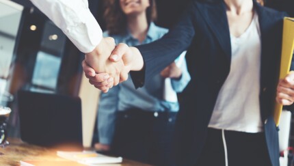 business people shake hands as part of forming a joint venture