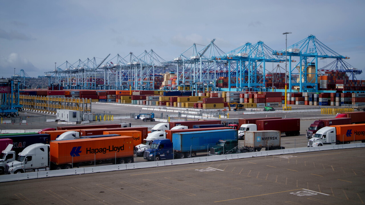 Trucks carrying shipping containers at the Port of Los Angeles.