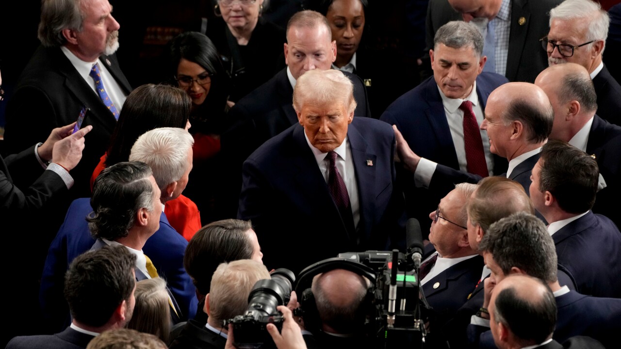 U.S. President Donald Trump departs following a joint session of Congress in the House Chamber while the crowd begins to engulf him.