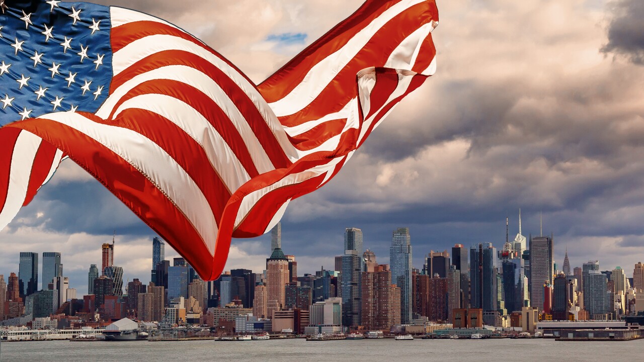 New York midtown panorama at dusk. The Empire State Building displays the colors of the American flag