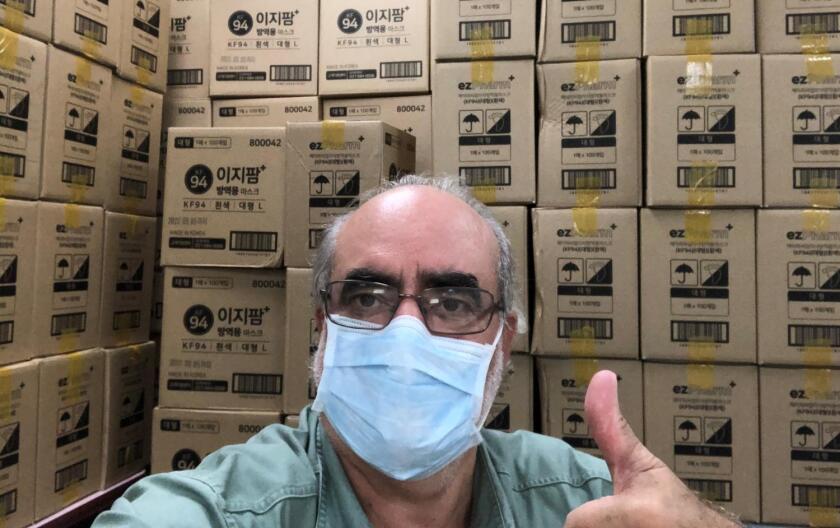 Brian Branch, president and CEO of the World Council of Credit Unions, poses in front of boxes of face masks donated by the Credit Union Federation of Korea. WOCCU will help distribute them to CUs around the world.