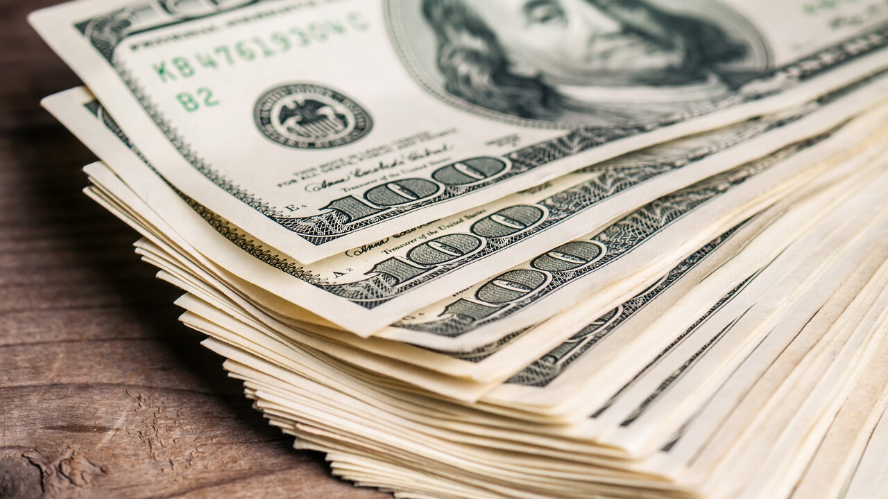 Fan of $100 bills on a desk