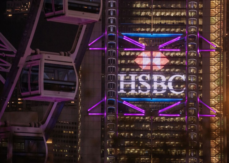 The HSBC headquarters building stands illuminated behind the Hong Kong Observation Wheel.