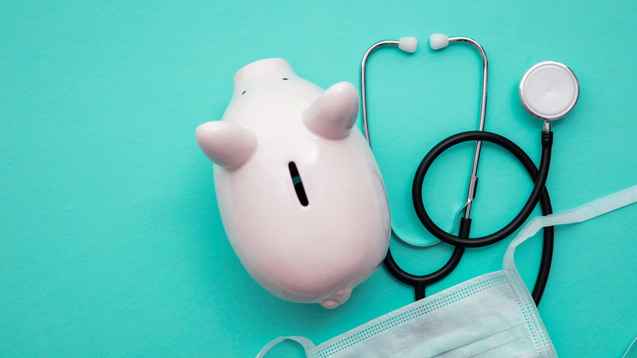 An overhead view of a piggy bank with medical supplies around it