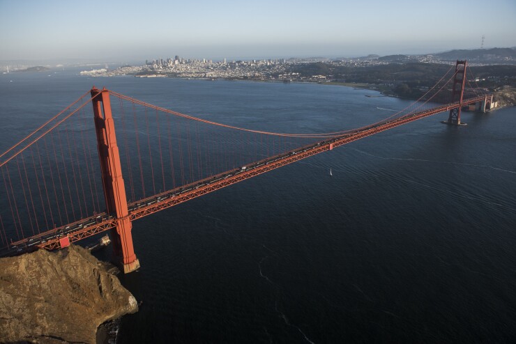 Cars travel across the Golden Gate Bridge in this aerial photograph taken above San Francisco, California, U.S., on Monday, Oct. 5, 2015. With tech workers flooding San Francisco, one-bedroom apartment rents have climbed to $3,500 a month, more than in any other U.S. city. Photographer: David Paul Morris/Bloomberg