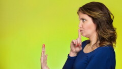 Closeup side view profile portrait serious woman finger, hand on lips, shhh gesture asking be quiet silence isolated green background. Negative facial expression sign emotion feelings, body language