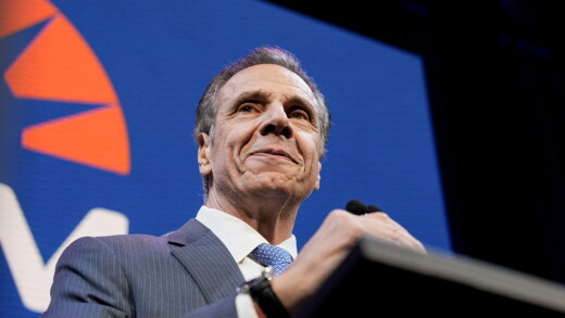 Andrew Cuomo smiles at a podium.