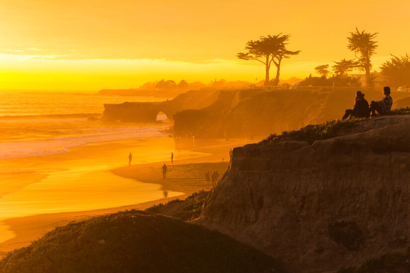 People enjoying the view of a stunningly colorful sunset in Sant