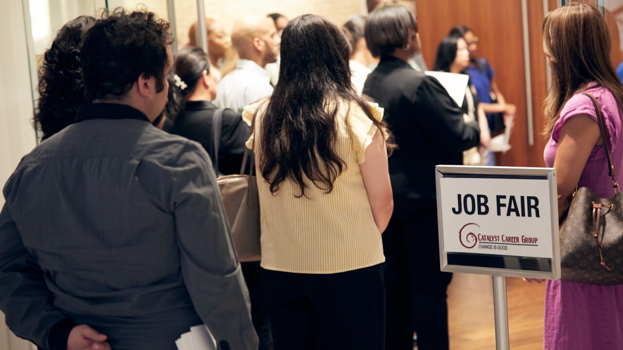A picture of people standing in line at a jobs fair.