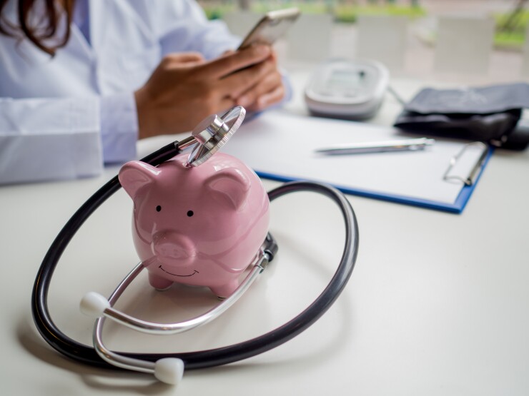 Pink piggy bank with doctor stethoscope, financial planning and health insurance