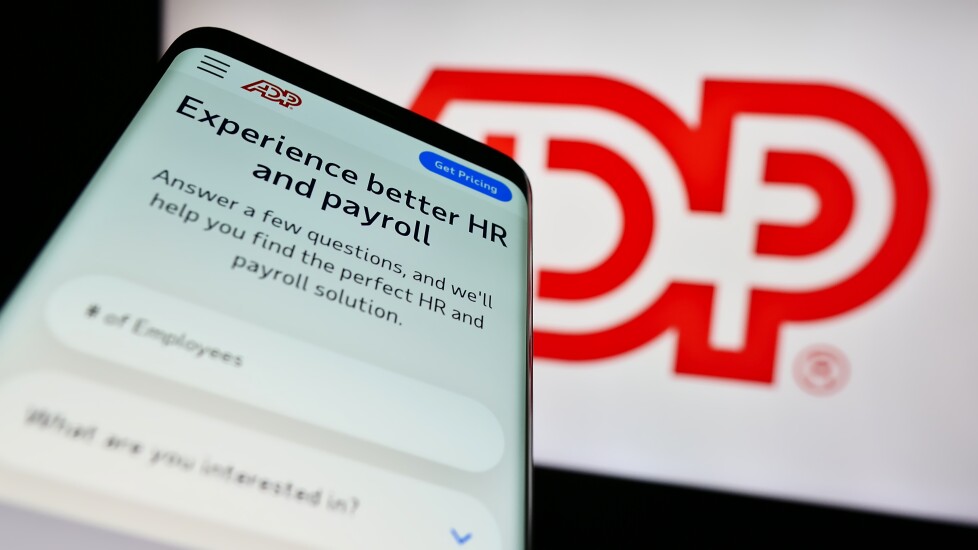 Stuttgart, Germany - 04-26-2023: Mobile phone with website of software company Automatic Data Processing Inc. (ADP) on screen in front of logo. Focus on top-left of phone display.