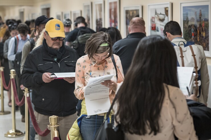 Voters look over their voter registration forms at the City Hall polling station in San Francisco, California, U.S., on Tuesday, June 5, 2018. 