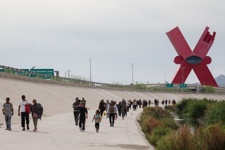 A picture of migrants walking along the Mexico-U.S. border in Ciudad Juarez, Mexico.