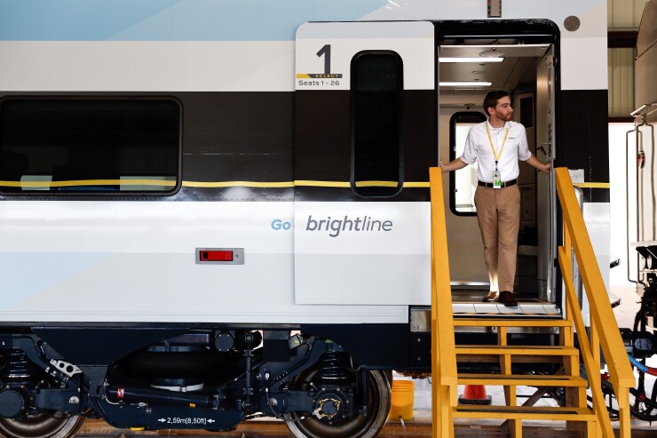 An All Aboard Florida representative looks out of a Brightline passenger train door during a media tour in West Palm Beach, Florida, U.S., on Wednesday, Jan. 11, 2017.