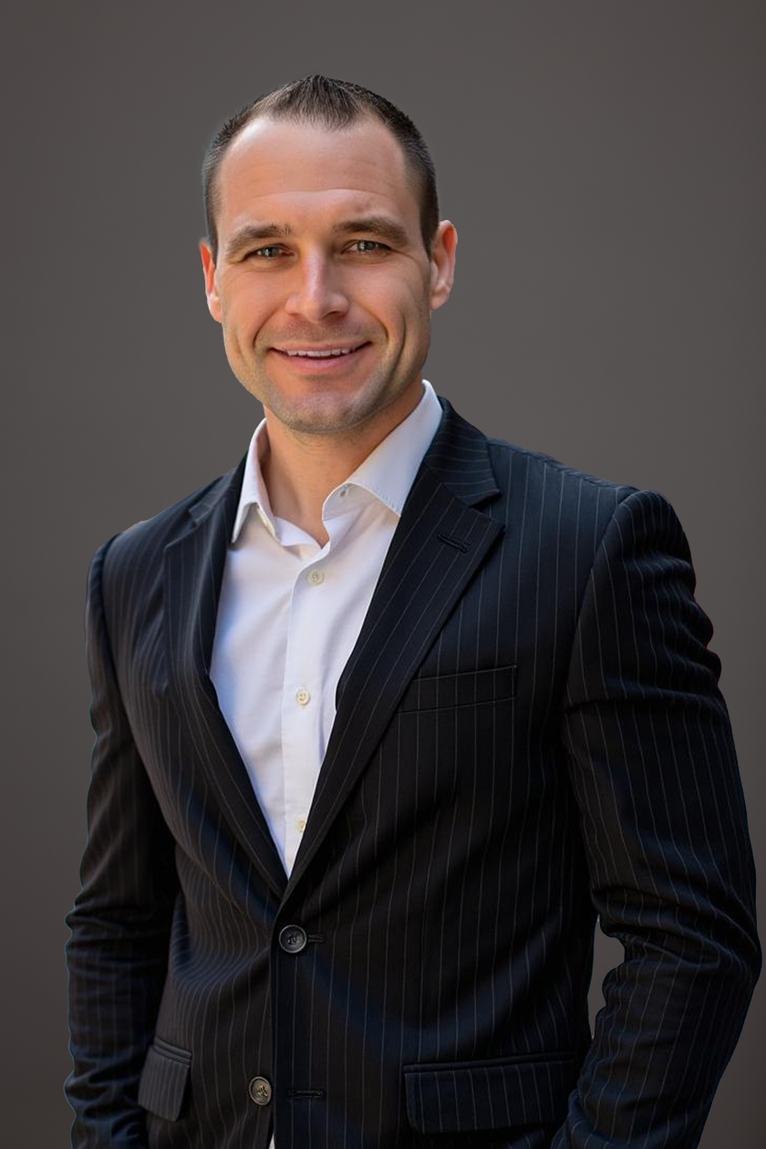 A man dressed in a blazer smiling for a photo.