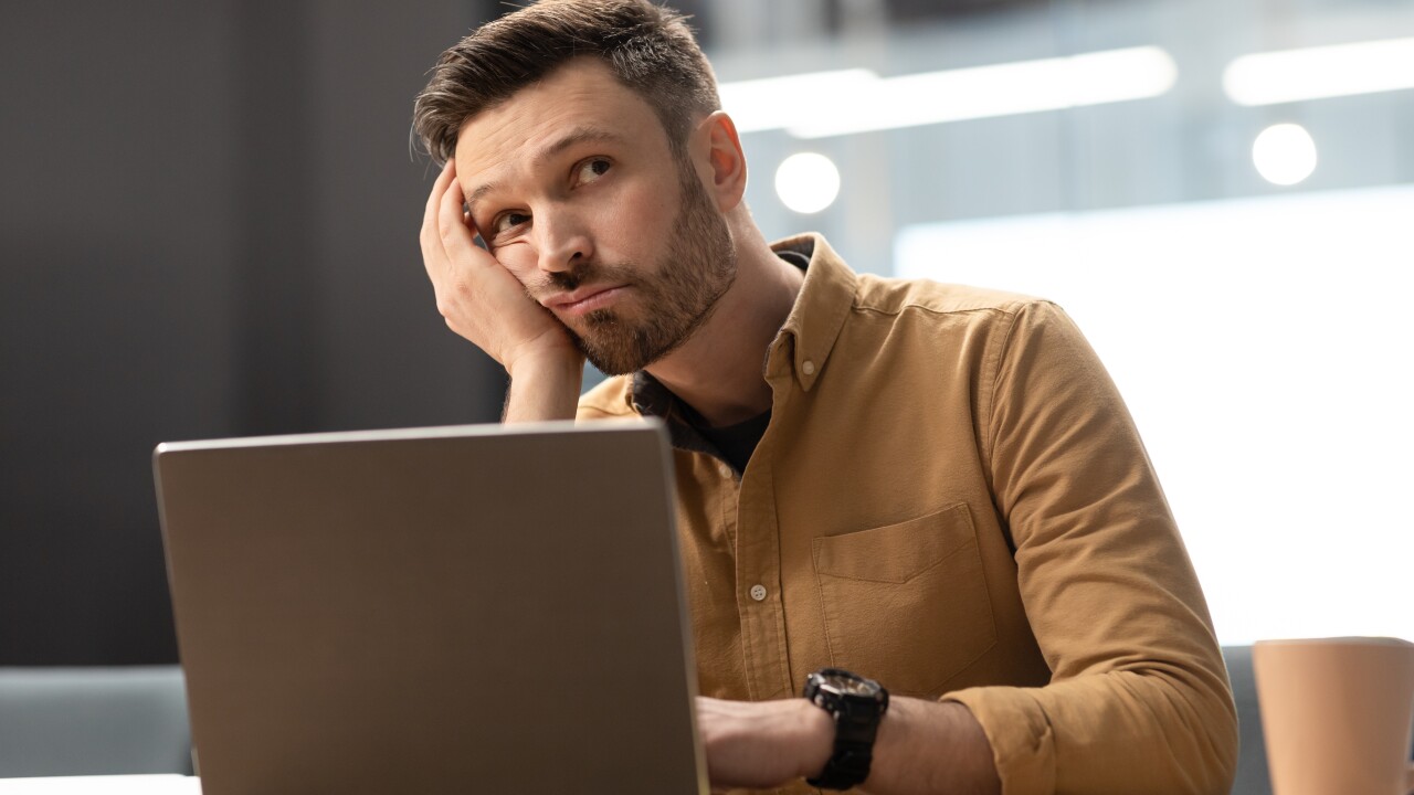 Man looking off into the distance while sitting at his computer
