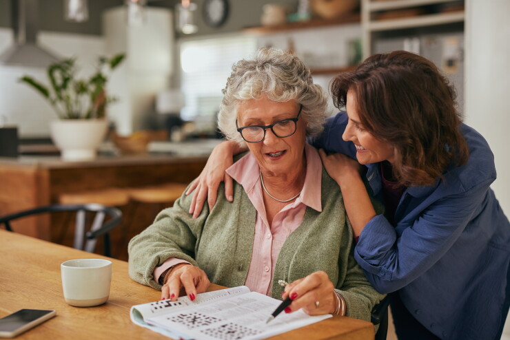 Woman hugging shoulders of mom, smiling