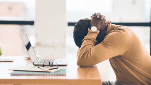 Employee with head on desk, sad, stressed
