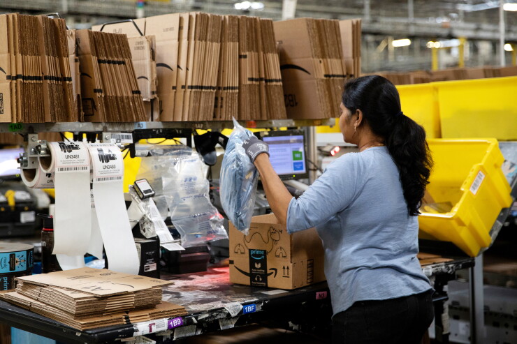 An employee packs a box at the Amazon.com Inc. fulfillment center in Robbinsville, New Jersey, U.S., on Thursday, June 7, 2018.