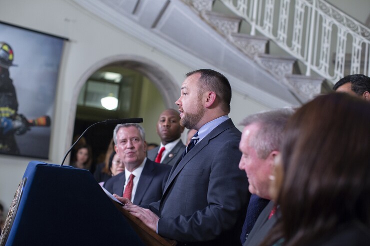 New York City Council Speaker Corey Johnson at the podium, with Mayor Bill de Blasio watching, as they announced a budget deal on June 11, 2018.