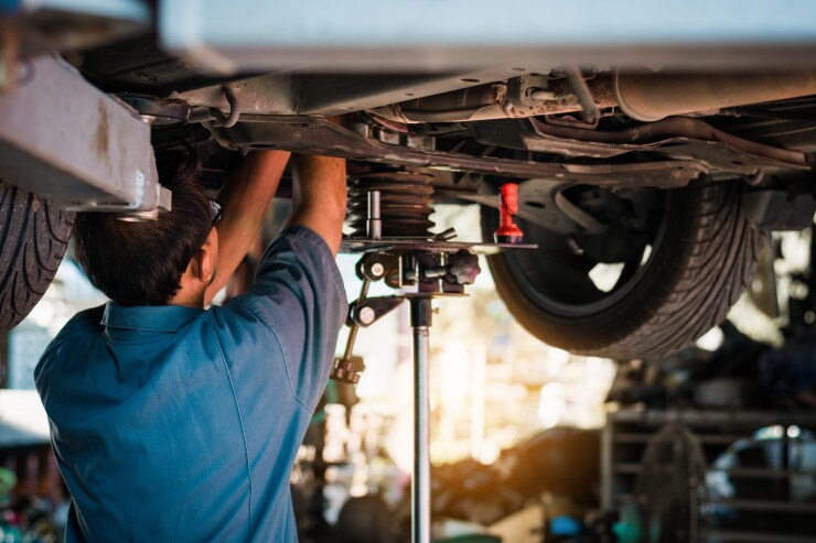 Mechanic repairing a car, Mechanic inspects car suspension syste