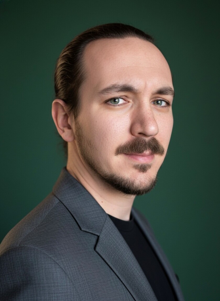 A man in dress clothes posing for a photo.