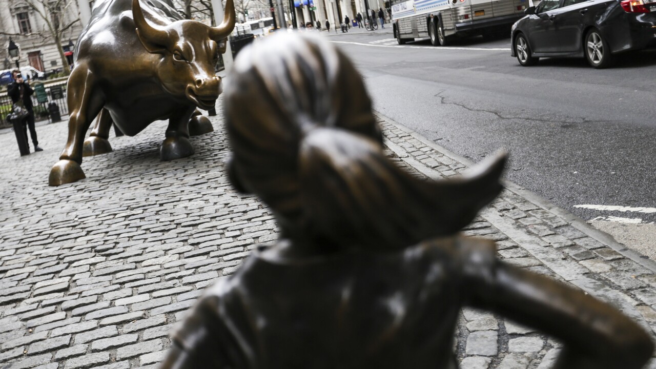 Statue of defiant girl facing the Charging Bull sculpture in Financial District of N.Y.