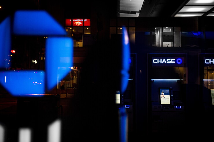 JPMorgan Chase signage and ATMs are illuminated at night at a bank branch in Chicago.