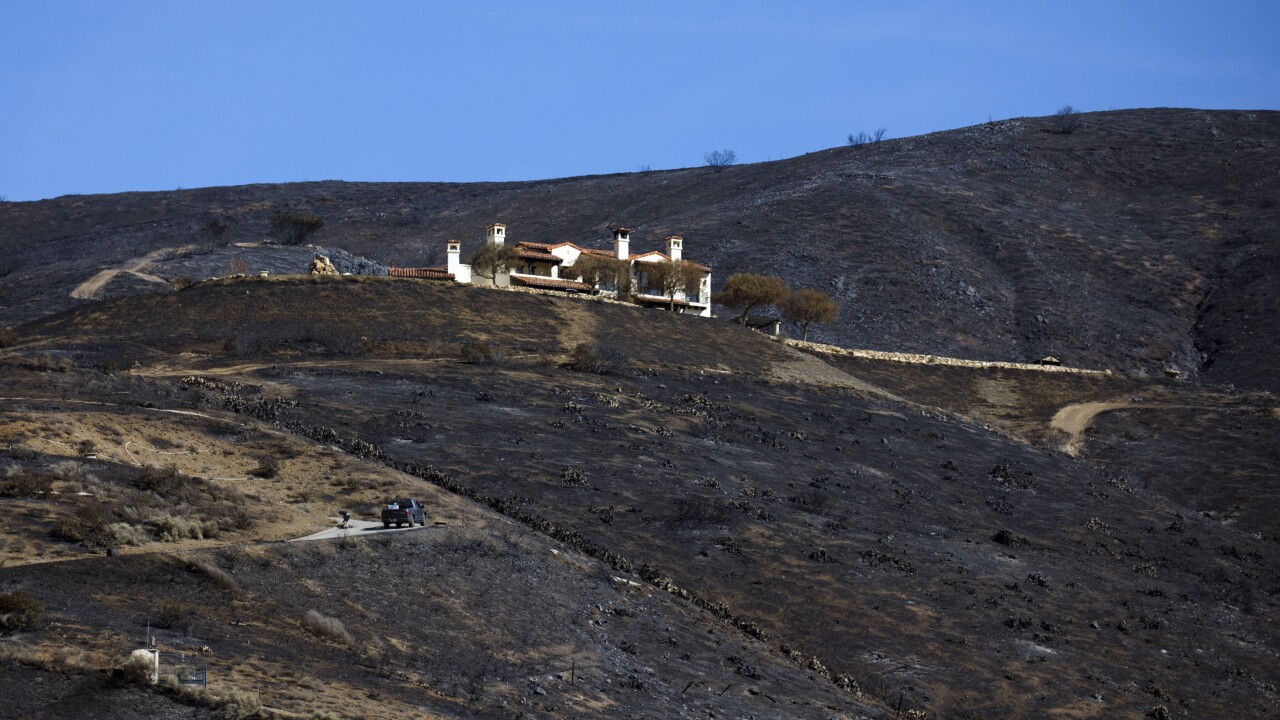 A home stands on a burned hillside during the Woolsey Fire in Malibu, California.