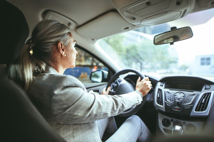 Woman in a business suit driving a car