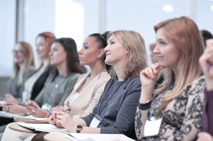 Women sitting and listening to speaker or presentation