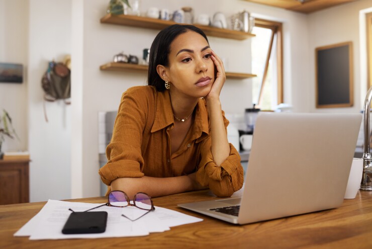Woman sitting at desk, bored