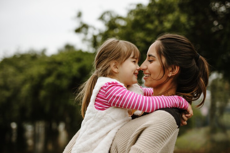 Mom holding daughter and smiling