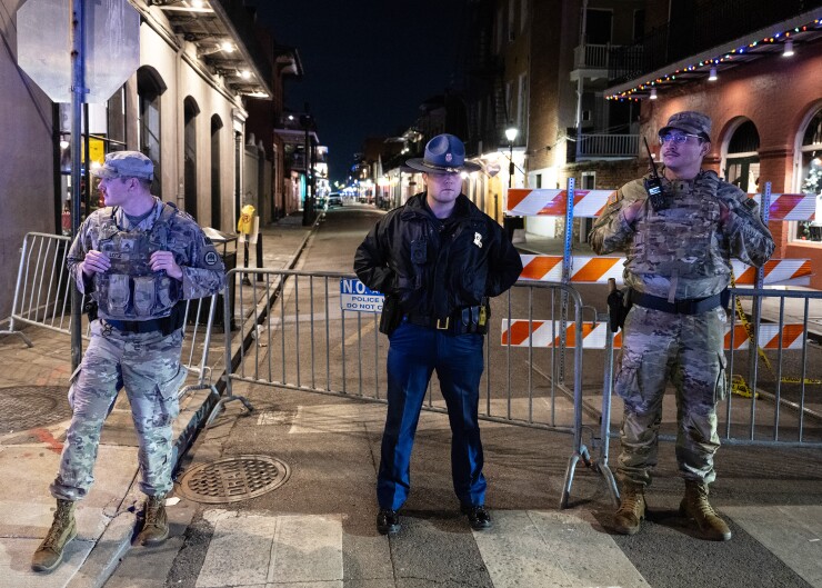 Members of the National Guard and police look on at a blocked off street, a block from Bourbon Street, after at least 15 people were killed in New Orleans