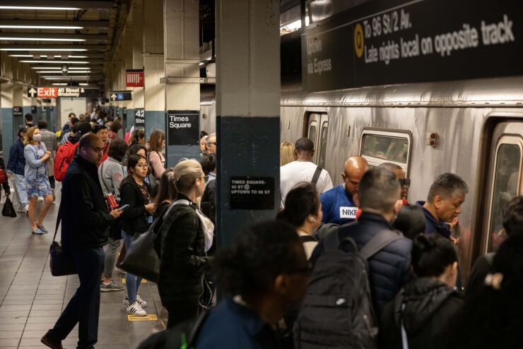 Passengers board a New York Subway train