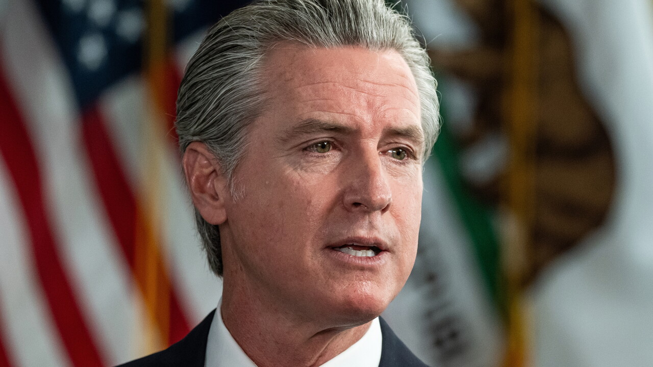 California Governor Gavin Newsom speaking with American flag in background